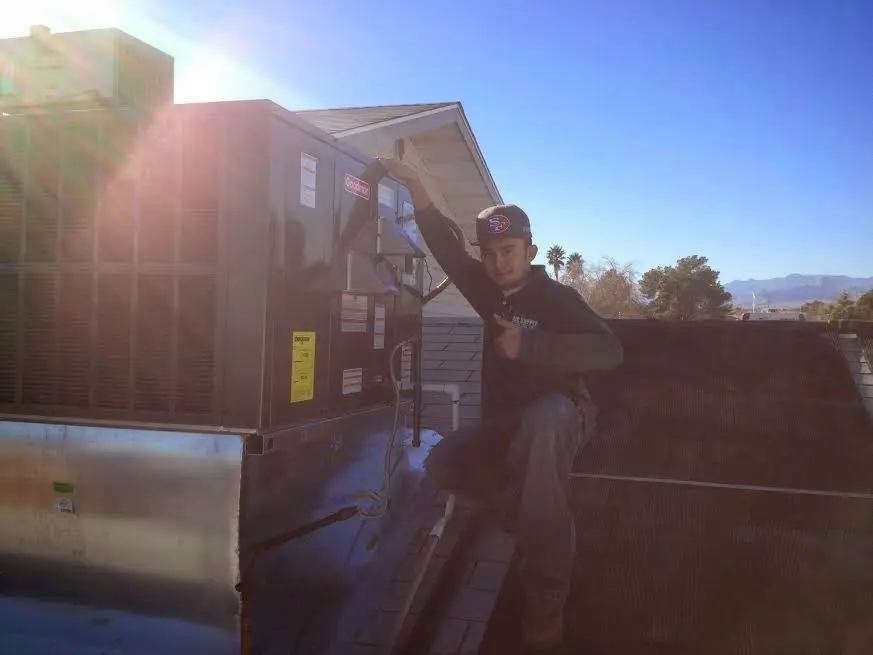 HVAC technician performing Air Duct Repair on a rooftop unit in Porter